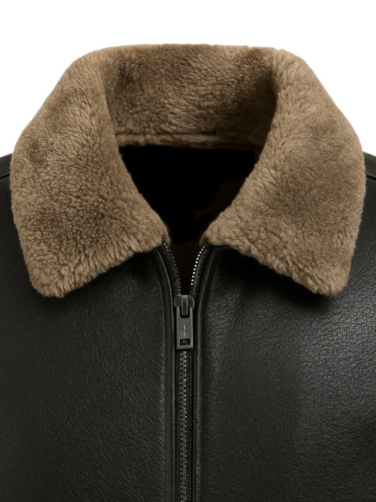 Close-up of a black leather jacket with a brown fur collar on a white background