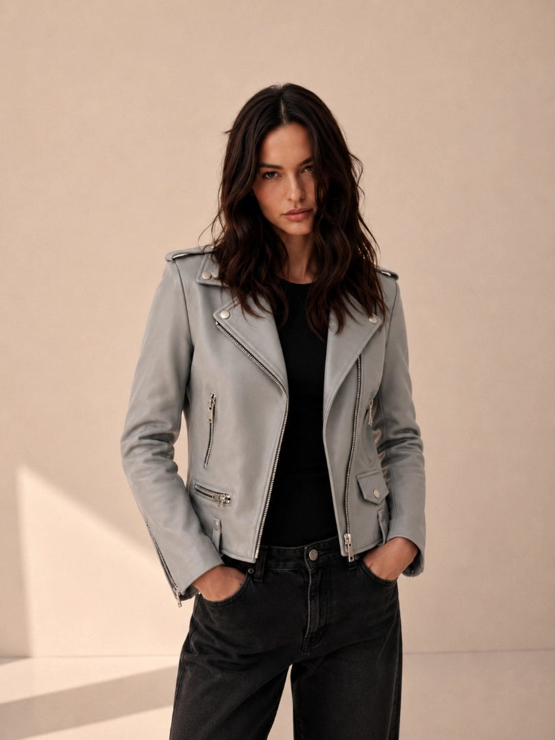 Woman wearing a gray leather jacket against a beige background