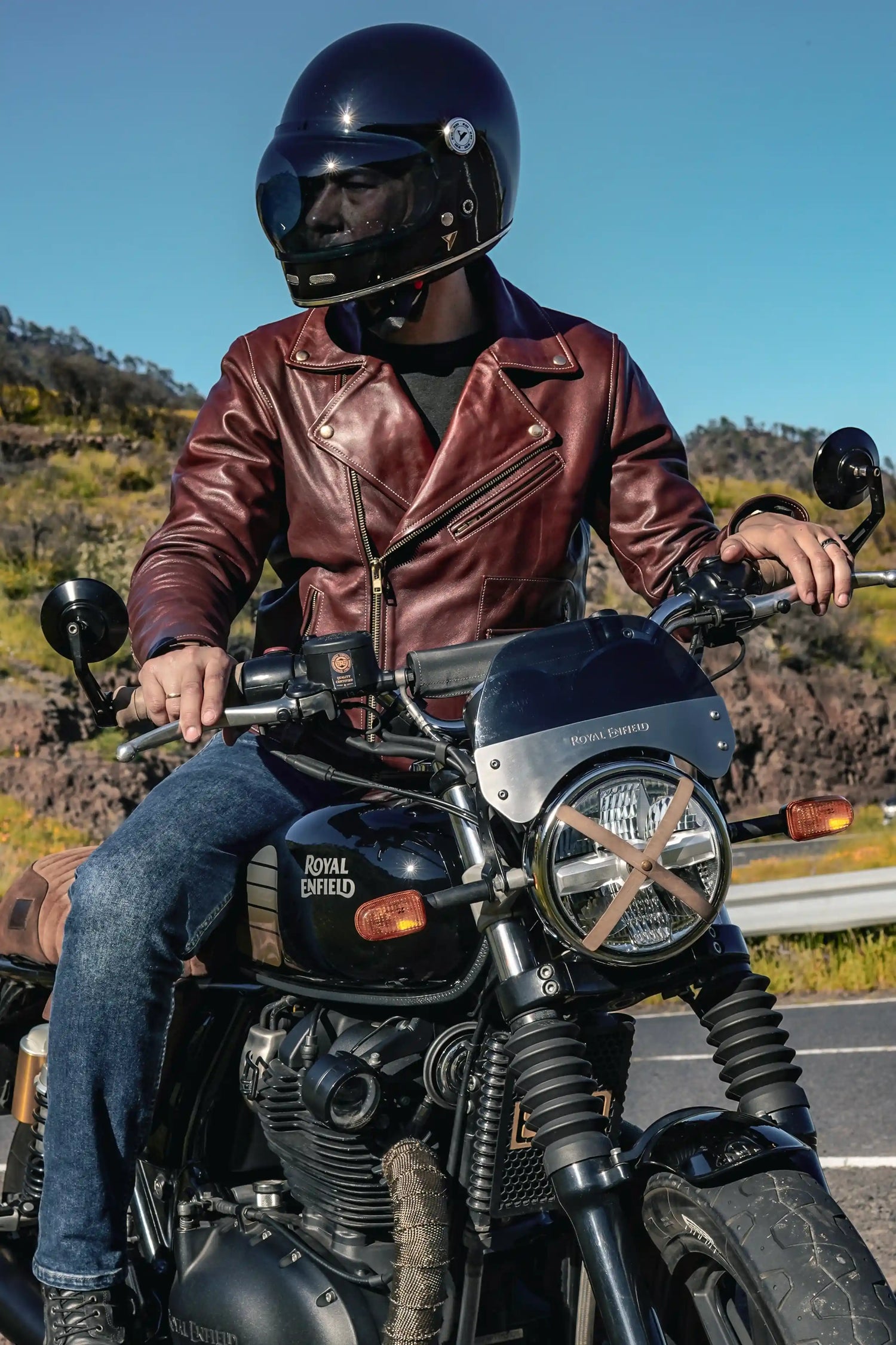Model wearing Rouven maroon biker leather jacket riding on a bike