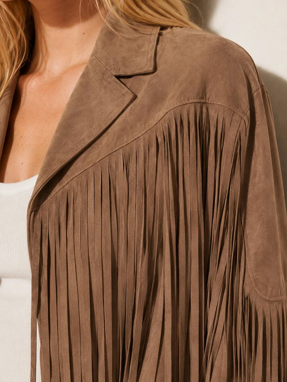 Brown suede fringe jacket worn by a person against a neutral background