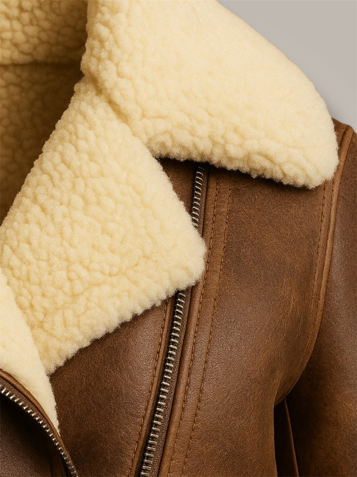 Close-up of a brown leather jacket with cream sheepskin lining.