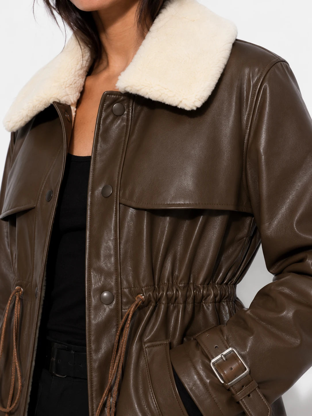 Brown leather coat with white fur collar on a neutral background