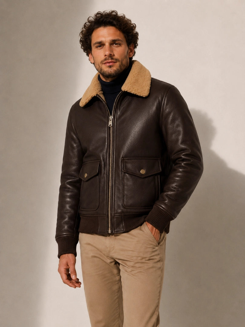 Man wearing a brown leather jacket with a fur-lined hood against a neutral background