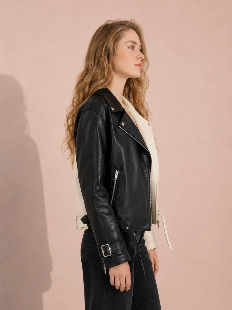 Woman wearing a black leather jacket against a pink background