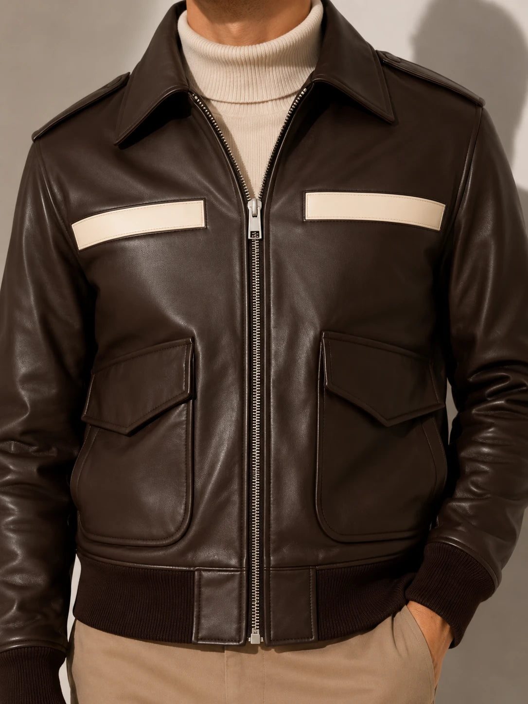 Brown leather jacket with white stripes on a neutral background