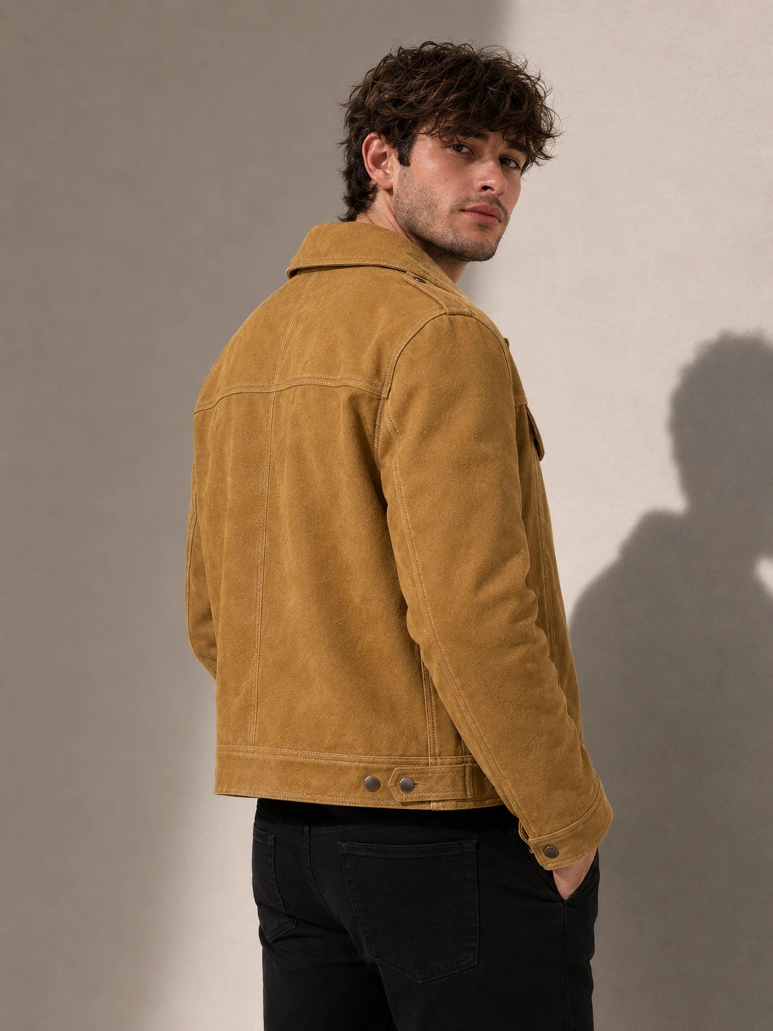 Man wearing a brown suede jacket against a plain background