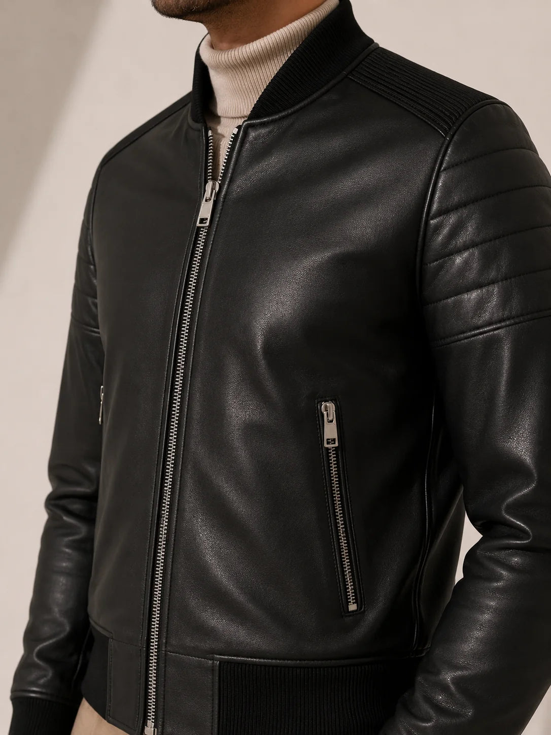 Black leather jacket with zippers on a neutral background