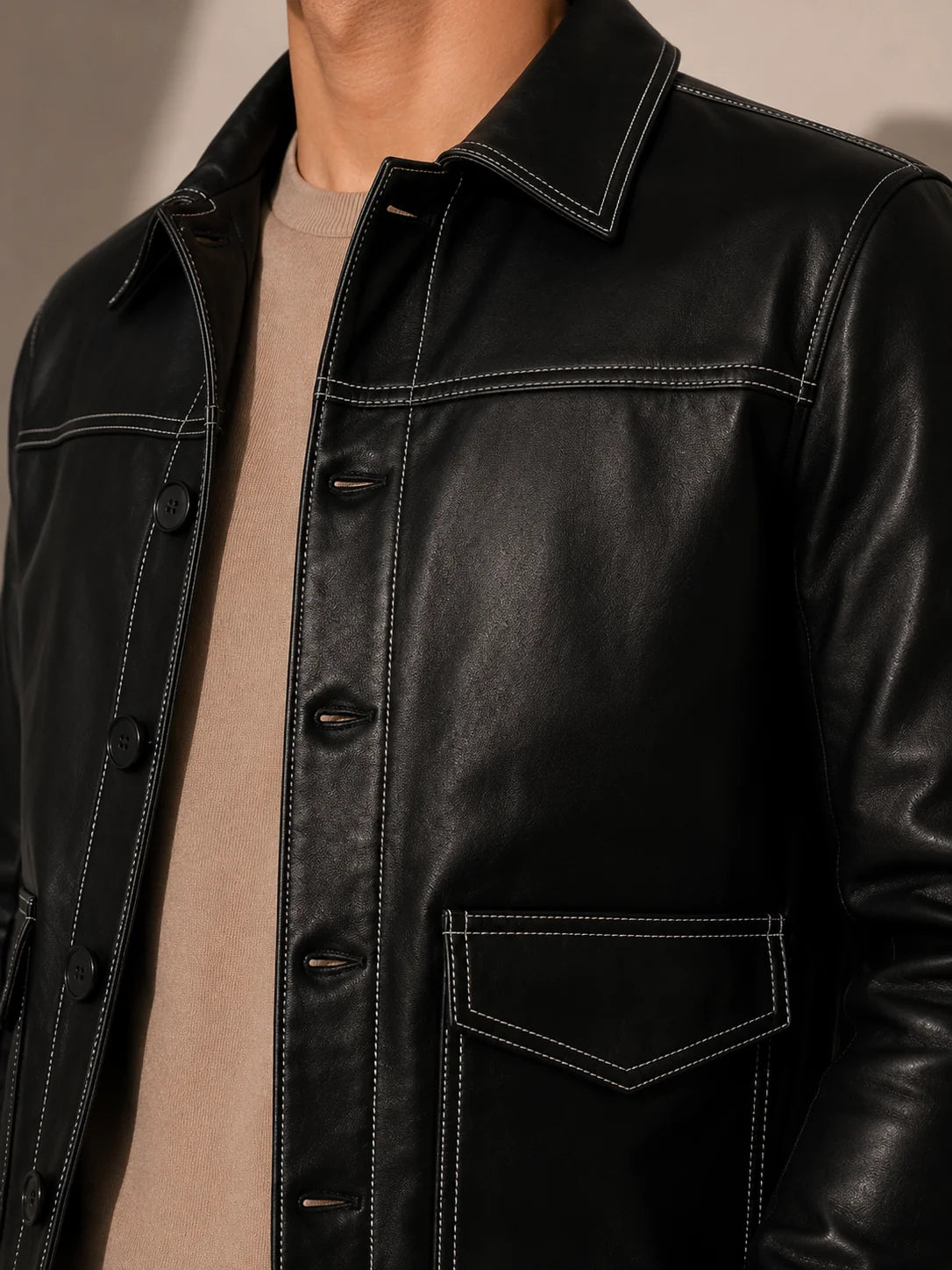Close-up of a black leather jacket with a neutral background