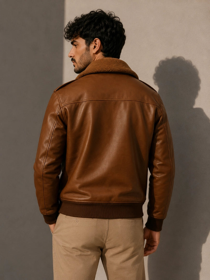 Man wearing a brown leather jacket against a plain background